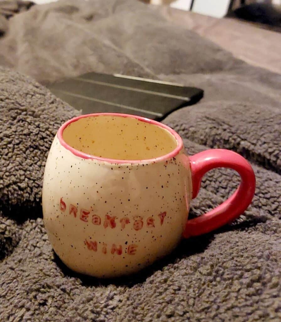 a beige and red colored coffee mug 